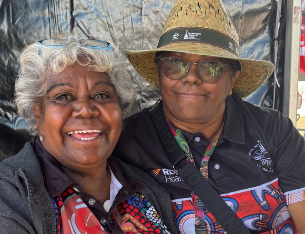 Two people smiling at the camera sitting down